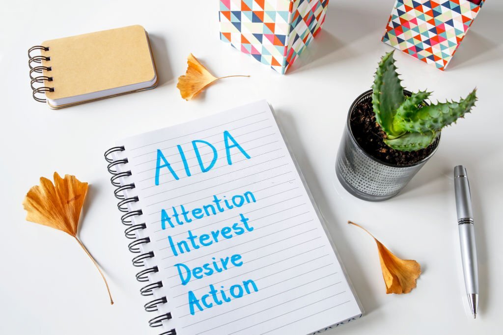 AIDA Attention Interest Desire Action written in a notebook on white table